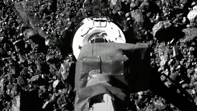 In this image from video released by NASA, the Osiris-Rex spacecraft touches the surface of asteroid Bennu on Tuesday, Oct. 20, 2020.