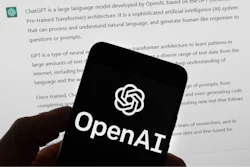 The OpenAI logo is seen on a mobile phone in front of a computer screen which displays output from ChatGPT, Tuesday, March 21, 2023, in Boston.