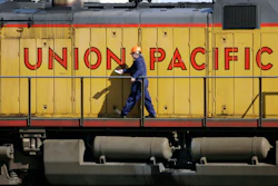 A maintenance worker walks past the company logo on the side of a locomotive in the Union Pacific Railroad fueling yard in north Denver, Oct. 18, 2006. Union Pacific announced Wednesday, Nov. 1, 2023, that it is trimming the ranks of the railroad's management employees as part of the new CEO's push to eliminate layers of bosses involved in decisions.