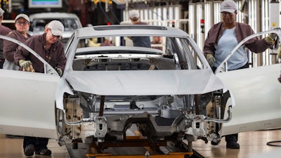 In this Aug. 31, 2017, file photo, workers produce vehicles at Volkswagen's U.S. plant in Chattanooga, Tenn.