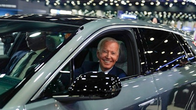 President Joe Biden drives a Cadillac Lyriq through the show room during a tour at the Detroit Auto Show, Sept. 14, 2022, in Detroit. The Biden administration has proposed new rules that could make it harder for electric vehicles to qualify for a full $7,500 federal tax credit. The rules announced Dec. 1 could complicate efforts to meet President Joe Biden's goal that half of new passenger vehicles sold in the U.S. run on electricity by 2030.