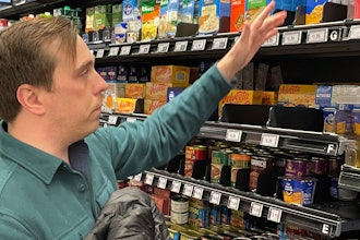 Stuart Dryden reaches for an item at a grocery store, Feb. 21, 2024, Arlington, Va.