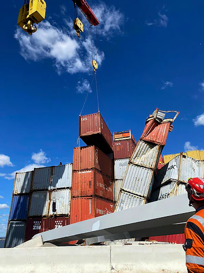 In this photo provided by the Key Bridge Response 2024 Unified Command, response crews begin removing shipping containers from the deck of the cargo ship Dali using a floating crane barge at the site of the Francis Scott Key Bridge, Sunday, April 7, 2024, in Baltimore.