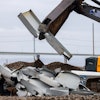 A machine splits a piece recovered from the collapsed Francis Scott Key Bridge at Tradepoint Atlantic on April 12, 2024, in Sparrows Point, Maryland.