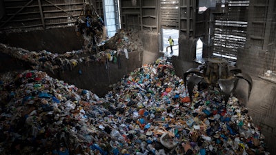 Cranes lift waste, mostly plastic and paper at the GreenNet recycling plant in Atarot industrial zone, north of Jerusalem, Jan. 25, 2023.