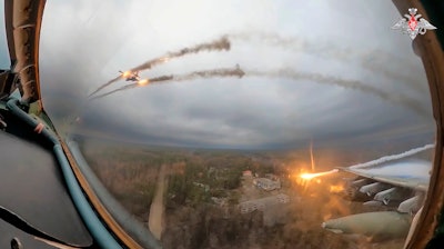 In this photo taken from video released by the Russian Defense Ministry Press Service on Monday, Jan. 22, 2024, a Su-25 warplane is seen from the cockpit of another such aircraft as they fire rockets on a mission over Ukraine.