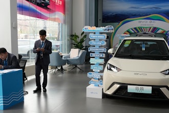 Sales staff stand near the Seagull electric vehicle from Chinese automaker BYD at a showroom in Beijing.