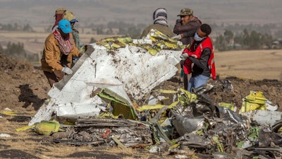 Workers recover debris at the scene of an Ethiopian Airlines Boeing Max plane crash on March 11, 2019, outside of Addis Ababa, Ethiopia.