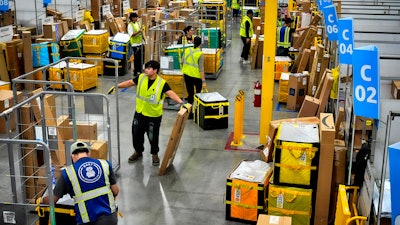 Amazon employees load packages at Amazon's DAX7 delivery station, South Gate, Calif., July 16, 2024.