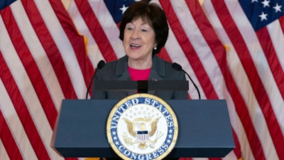 Sen. Susan Collins, R-Maine, speaks in front of American flags during the Congressional Gold Medal ceremony in honor of 'Rosie the Riveter', Wednesday, April 10, 2024, on Capitol Hill in Washington.