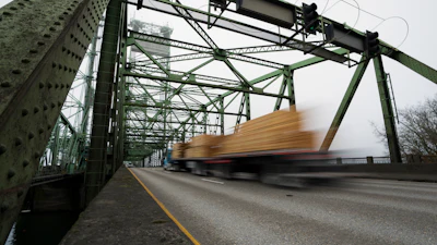 A logging truck drives on the Interstate 5 bridge that spans the Columbia River and connects Portland, Ore., with southwest Washington state, Feb. 13, 2024.