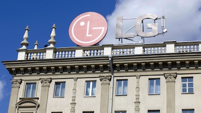 The emblem of the corporation LG on the roof of a historic building.