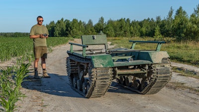 Andrii Denysenko, CEO of design and production bureau 'UkrPrototyp', stands by Odyssey, an 800-kilogram (1,750-pound) ground drone prototype, at a corn field in northern Ukraine, Friday, June 28, 2024.