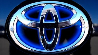 Toyota logo (Hybrid model) is seen at a new and used vehicles dealership in Palatine, Ill., Tuesday, March 20, 2024.