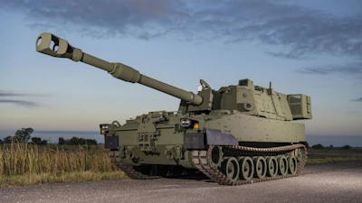 Green M109A7 Self-Propelled Howitzer on a gravel road.