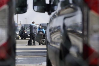 Amazon drivers wait next to their delivery vans after logistics systems went offline at the Amazon Delivery Station in Rosemead, Calif., Dec. 7, 2021.