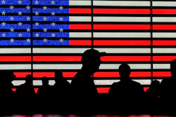 People gather near an electronic display of an American flag in Times Square in New York on Aug. 9, 2024.