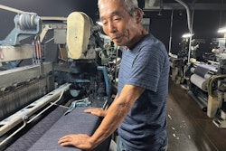Weaving craftsman Shigeru Uchida examines the evenness of the fabric being woven by the old power looms at Momotaro Jeans in Kojima, Okayama prefecture, Japan, on Sept. 4, 2024.