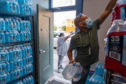 Chris Cowan with Cascadia Behavioral Healthcare's street outreach team loads water and other cooling supplies before visiting homeless camps, Aug. 12, 2021, in Portland, Ore.