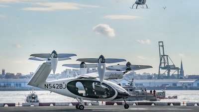 An electric vertical takeoff and landing (eVTOL) aircraft, flies above the Joby eVTOL aircraft, during a demonstration of eVTOLs Nov. 13, 2023, in New York.