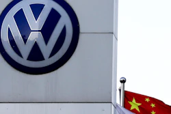 A Chinese national flag flutters near a Volkswagen logo in Beijing, Tuesday, April 18, 2017.