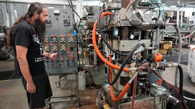 Chuck Springer operates a record pressing machine at the United Record Pressing plant July 11, 2024, in Nashville, Tenn.