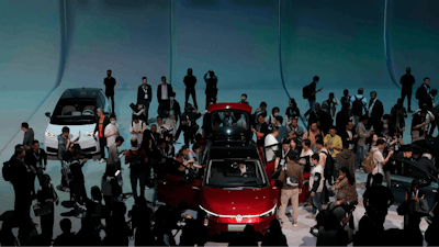 Attendees take a close look at the Volkswagen ID.7 Vizzion, a new electric flagship sedan during a world premiere on the eve of the Auto Shanghai 2023 show in Shanghai, China, April 17, 2023.
