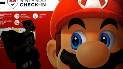A traveler walks past an advertisement featuring a Nintendo character at Narita airport in Narita near Tokyo, on June 10, 2022.