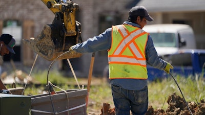 A worker lays a cable at a home building site in Flowood, Miss. on Sept. 23, 2021.