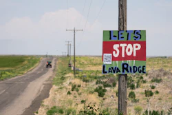 A tractor travels down Hunt Road in front of a 'Let's Stop Lava Ridge' sign near the Minidoka National Historic Site, July 6, 2023, in Jerome, Idaho.