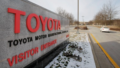 A car drives past the entrance to the Toyota Motor Manufacturing plant is seen in Georgetown, Ky., Jan. 27, 2010.