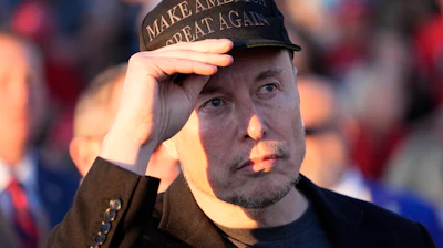 Elon Musk listens as Republican presidential nominee former President Donald Trump speaks at a campaign event at the Butler Farm Show on Oct. 5, 2024, in Butler, Pa.