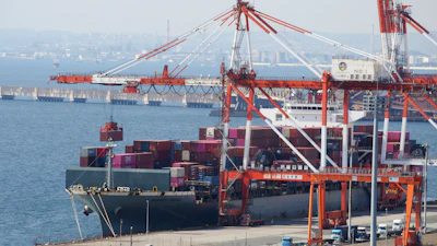 A container ship is loaded and unloaded at a container terminal at a port of Kawasaki near Tokyo on March 9, 2022.