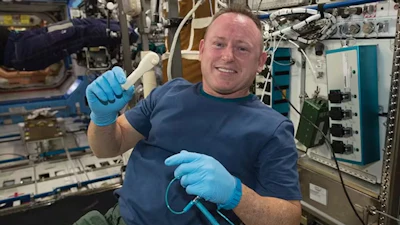 NASA astronaut Barry Wilmore holds a 3D-printed wrench made aboard the International Space Station.