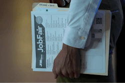 A person waits in a line for a prospective employer at a job fair, Thursday, Aug. 29, 2024, in Sunrise, Fla.