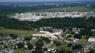 The Fifth Ward Elementary School and residential neighborhoods sit near the Denka Performance Elastomer Plant, back, in Reserve, La., Sept. 23, 2022.
