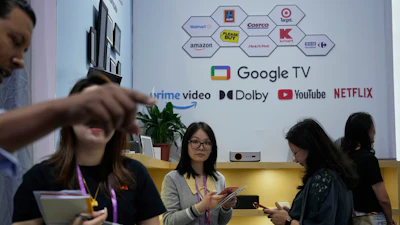 Sales rep promote projectors at the 137th Canton Fair in Guangzhou in southern China's Guangdong province on Tuesday, April 15, 2025.