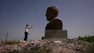 A visitor photographs a large bust of Elon Musk near SpaceX's Starbase as the Starship is prepared for a test flight in Boca Chica, Texas, March 5, 2025.
