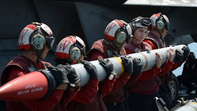 In this handout photo from the U.S. Navy, sailors load an AIM-120C missile into an F/A-18E Super Hornet aboard the aircraft carrier USS Nimitz in the Persian Gulf on Aug. 8, 2017.
