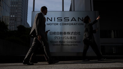Visitors walk past Nissan signage at Nissan headquarters in Yokohama, Tuesday, May 13, 2025.