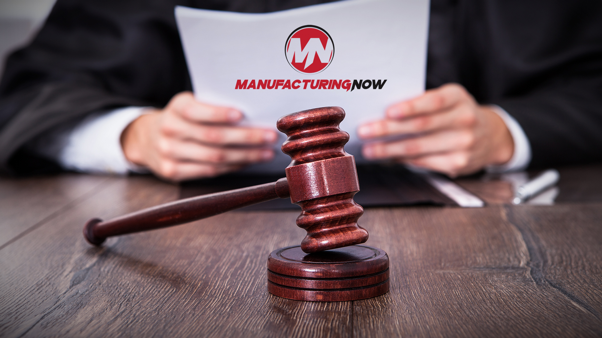 Legal document with ManufacturingNow logo and wooden gavel on professional desk