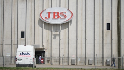 In this Friday, July 22, 2021, photograph, employees move into an entrance to the JBS meat processing plant in Greeley, Colo.