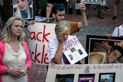 Protesters who have lost love ones to the opioid crisis protest outside a courthouse in Boston, Aug. 2, 2019, where a judge heard arguments in a lawsuit against Purdue Pharma.