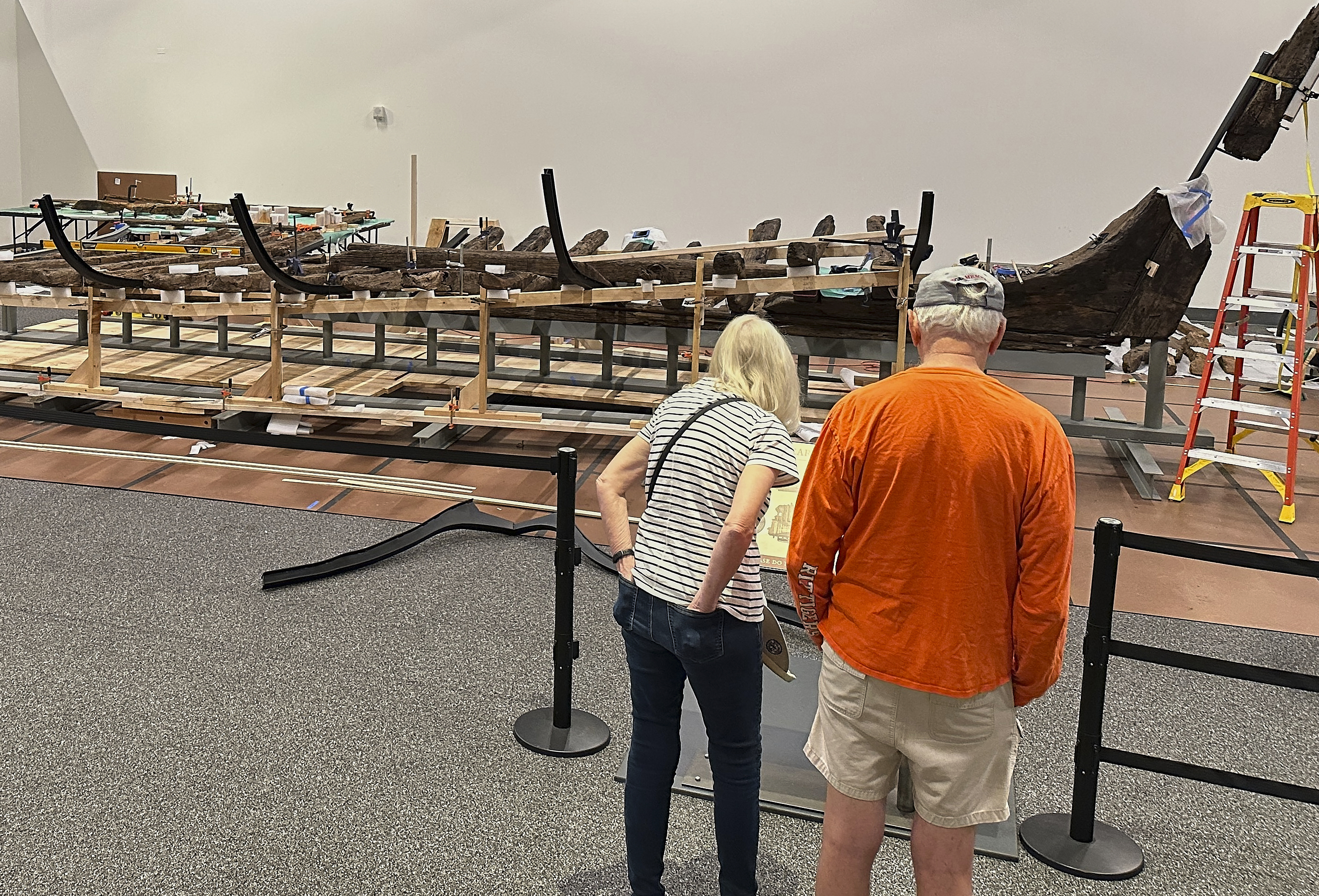 Visitors to the New York State Museum view a Revolutionary War-era gunboat that is being partially reconstructed, Friday, May 30, 2025, in Albany, New York.