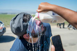 Milk is poured on a protester's face after federal immigration agents tossed tear gas at protesters during a raid in the agriculture area of Camarillo, Calif., Thursday, July 10, 2025.