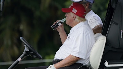 President Donald Trump drinks a Diet Coke during the ProAm of the LIV Golf Team Championship at Trump National Doral Golf Club, Oct. 27, 2022, Doral, Fla.
