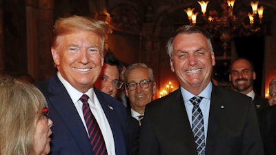 Brazil's President Jair Bolsonaro, right, stands with President Donald Trump during a dinner at Mar-a-Lago, Palm Beach, Fla., March 7, 2020.