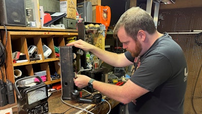 Patrick Schlott repairs an old payphone in his basement workshop on July 16, 2025, in Williamstown, Vt.
