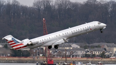 Salvage crews work on recovering wreckage near the site in the Potomac River of a mid-air collision between an American Airlines jet and a Black Hawk helicopter at Ronald Reagan Washington National Airport, Thursday, Feb. 6, 2025, in Arlington, Va.