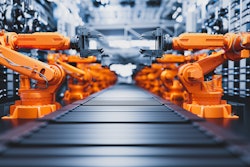 Industrial robotic arms positioned symmetrically on automated manufacturing assembly line.